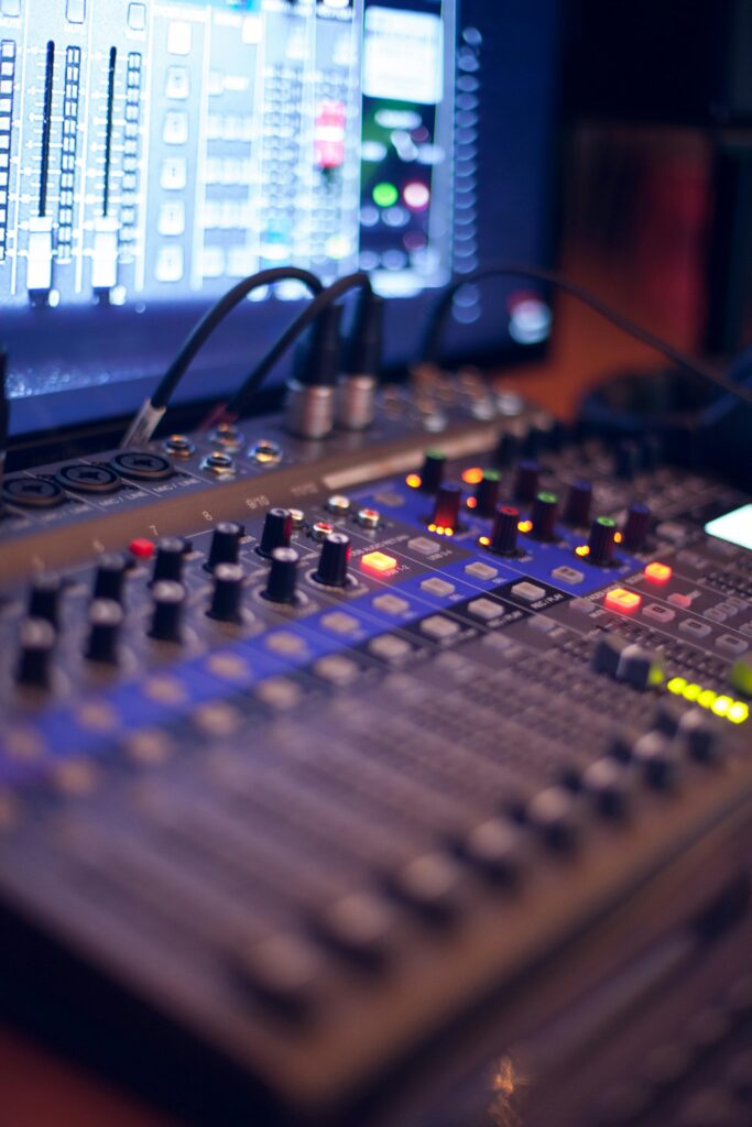 pexels photo 1436141 1436141 Close-up of a professional audio mixing console with glowing LED indicators.