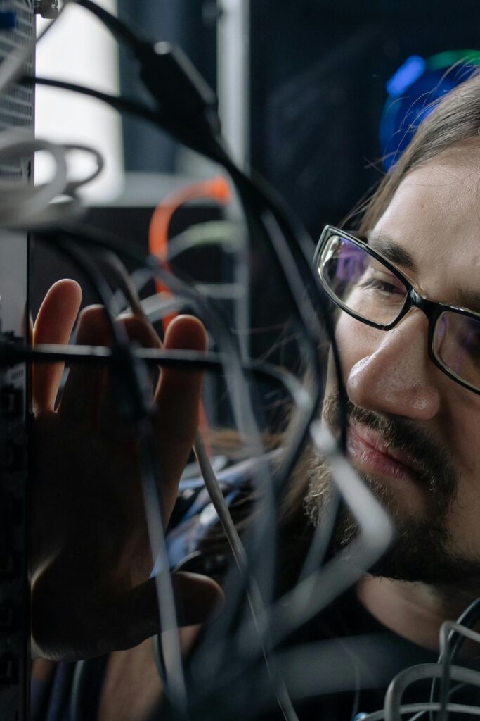 pexels photo 6804586 6804586 Professional IT specialist handling network cables in a server room.